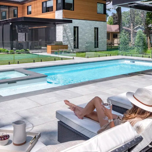 Image de la piscine creusée du modèle Saphir en couleur sel de mer avec des dalles Proma 3XL en couleur gris ciel